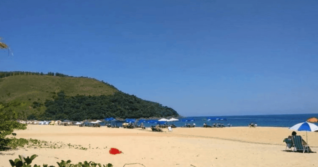 Praia Paúba (São Sebastião) com turistas na areia no litoral norte de SP
