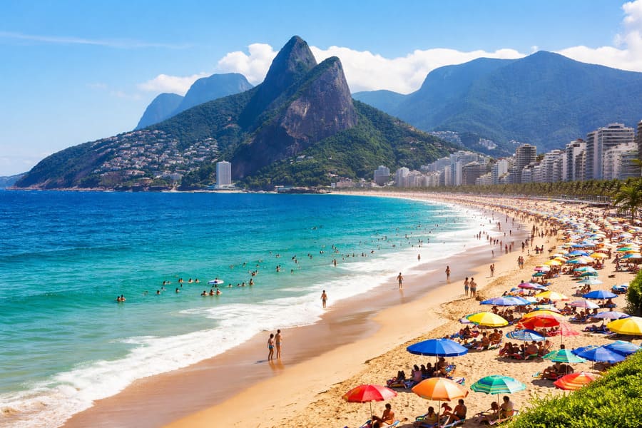Vista de praia do Rio de Janeiro com mar azul e faixa de areia cheia de banhistas, destino ideal para quem busca praia barata e passagem para o Rio de Janeiro.