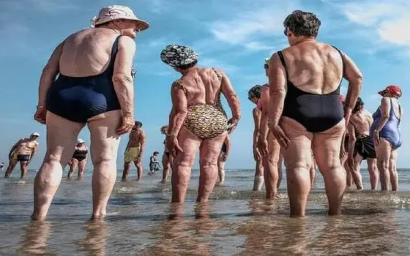 Grupo de pessoas idosas se exercitando na beira de uma praia: o melhor destino para a terceira idade