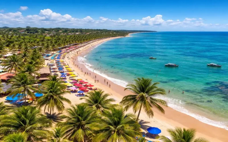 Praia de Porto Seguro, na Bahia, com mar azul-turquesa, coqueiros e faixa de areia movimentada em um dia ensolarado, um dos principais destinos turísticos do Brasil.